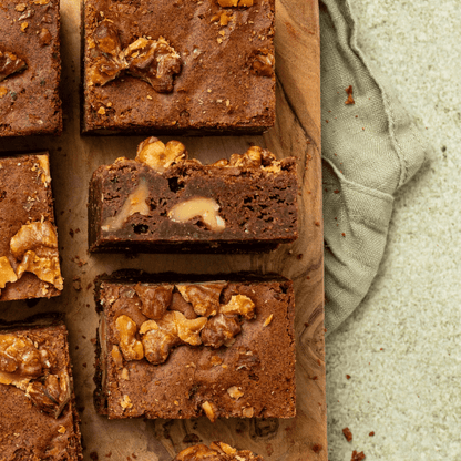Doorsnede van een smeuïge walnootbrownie met stukken walnoot